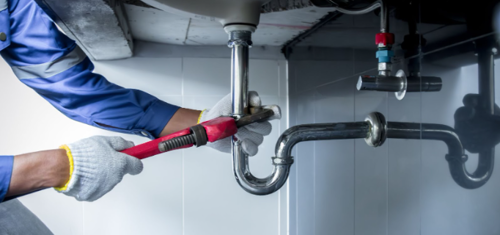 Plumber in Murfreesboro TN hands holding wrench doing repairing work at the sink and clogged pipe in bathroom carefully.