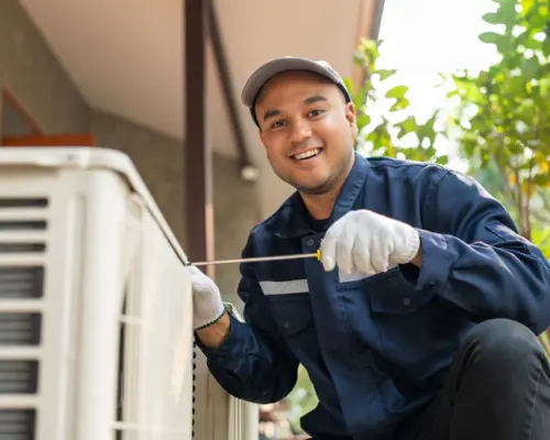 A contractor working on an HVAC unit as part of a comprehensive HVAC Guide for Homeowners.