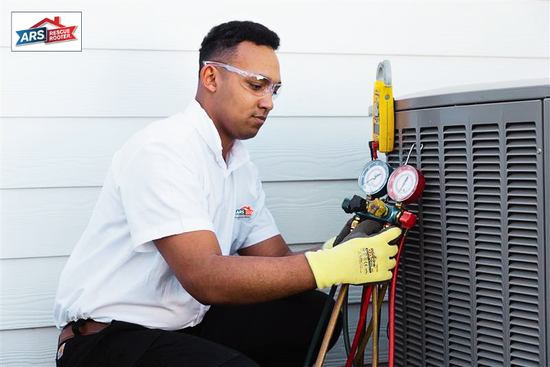 ARS professional performing a routine maintenance check with a pressure guage tool. 